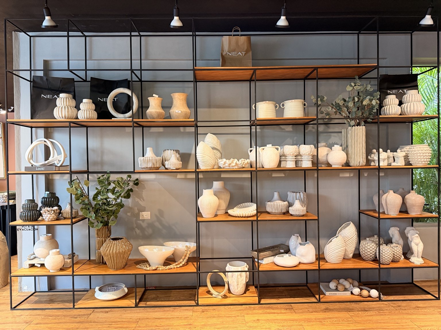 Vista frontal de los anaqueles de madera y herrería dentro de NEAT Decoración