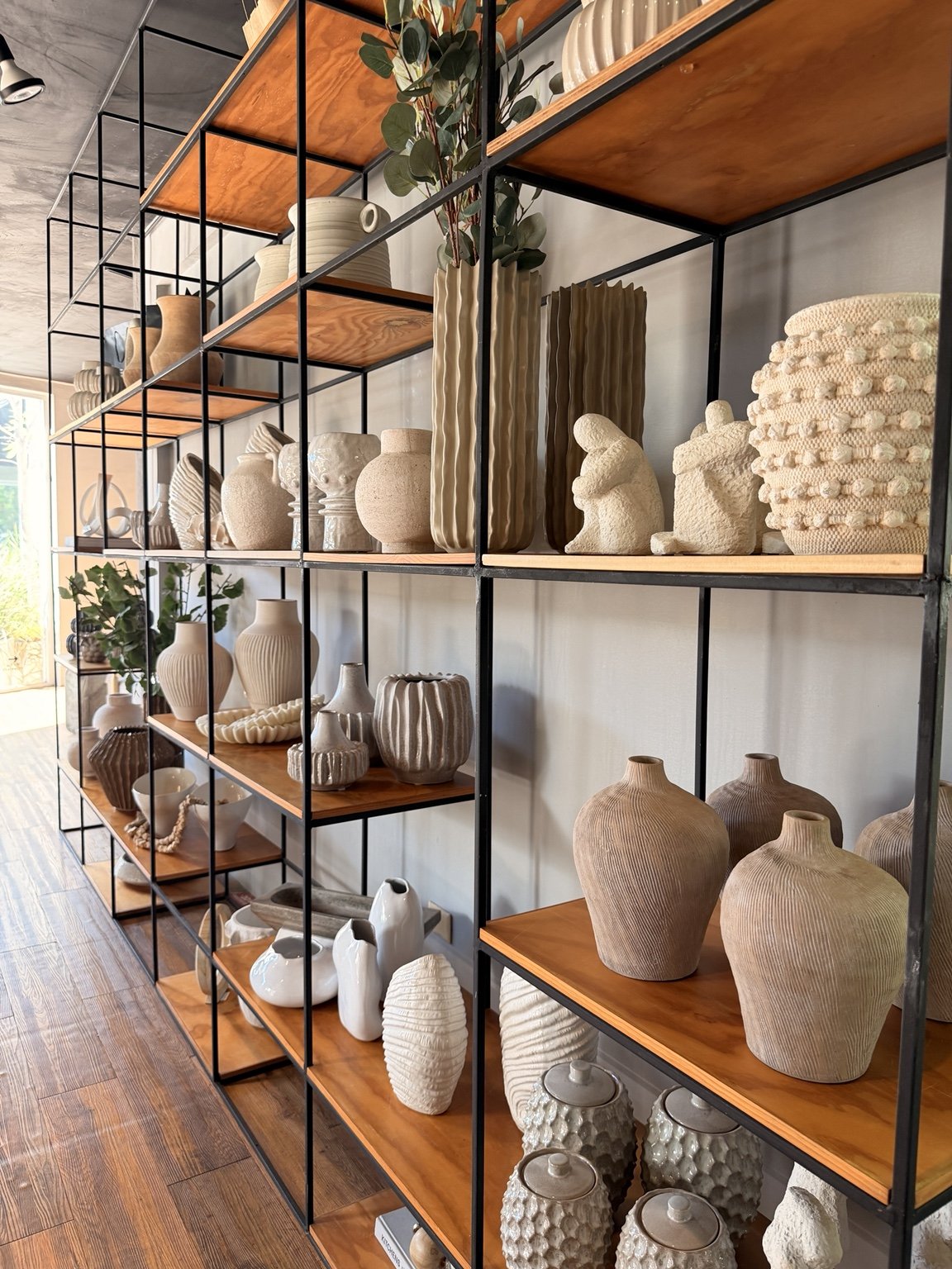 Interior de la tienda NEAT con anaqueles de jarrones y accesorios